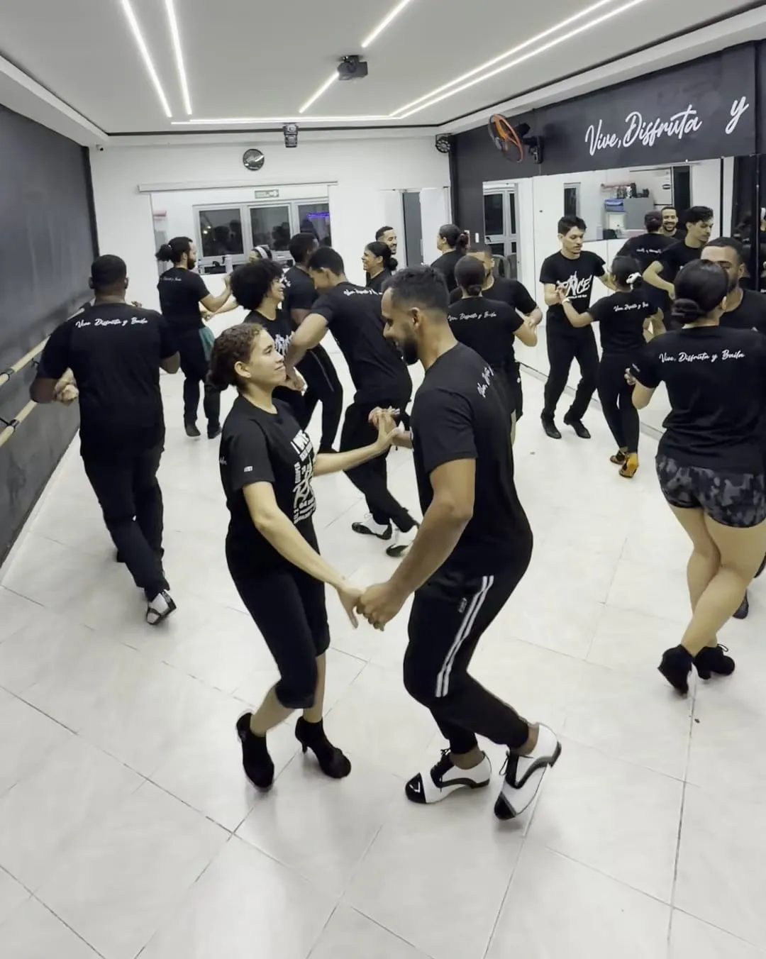 Parejas de Raíces bailando en el salón de la escuela